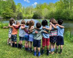 friends with arms around each other at pond