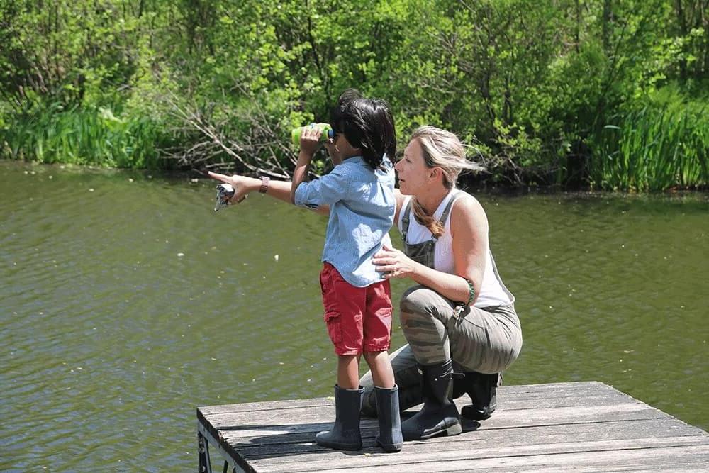 Teacher on Dock Pointing with a student using binoculars